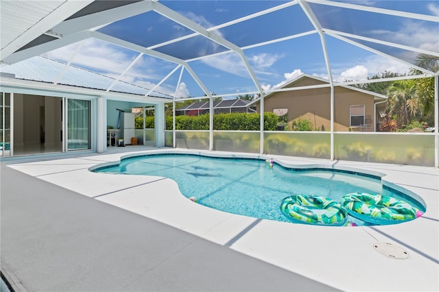 outdoor pool with glass enclosure and a patio