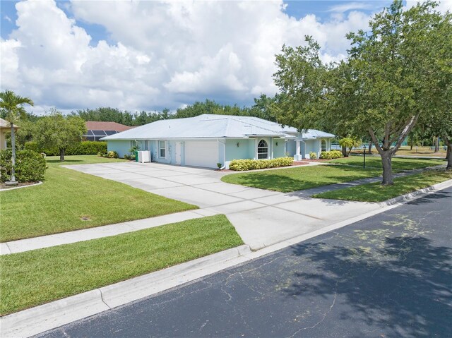 single story home with concrete driveway, an attached garage, and a front yard