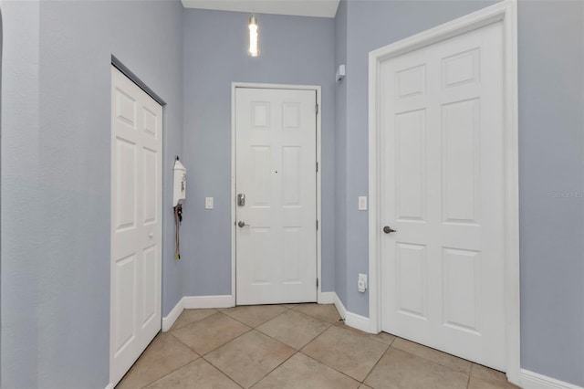 entryway with baseboards and light tile patterned flooring