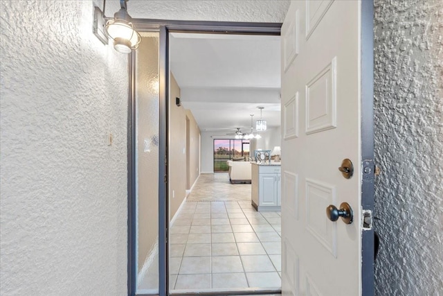 hallway featuring light tile patterned floors and baseboards