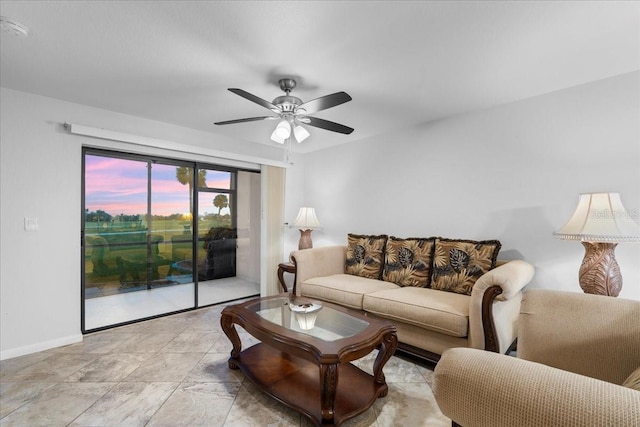 living area with ceiling fan and baseboards