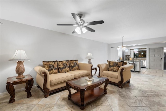 living room featuring light tile patterned flooring, a ceiling fan, and baseboards