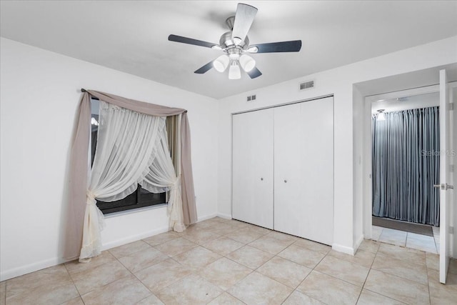 unfurnished bedroom with light tile patterned floors, baseboards, visible vents, and a closet