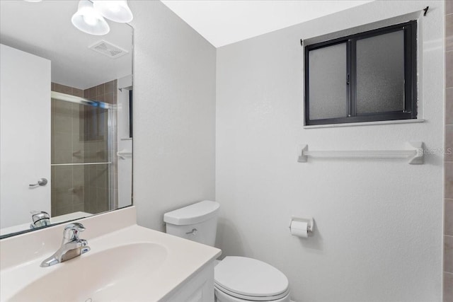 full bath with toilet, visible vents, a tile shower, and vanity