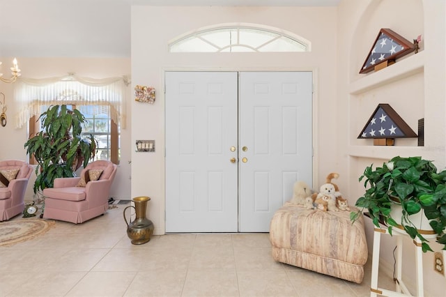 tiled foyer featuring a notable chandelier