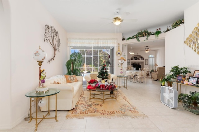 living area featuring a fireplace, tile patterned flooring, and a ceiling fan