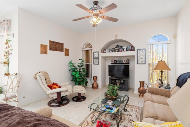 living area with built in shelves, tile patterned flooring, and a ceiling fan