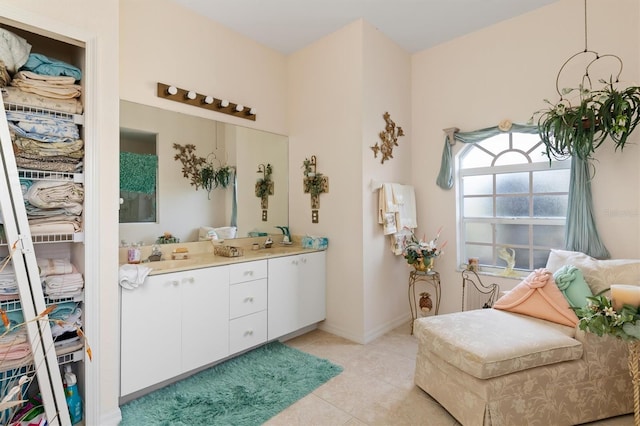 bathroom featuring baseboards, double vanity, and tile patterned floors