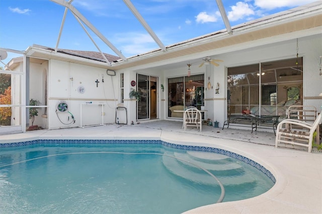 pool featuring a ceiling fan, glass enclosure, and a patio