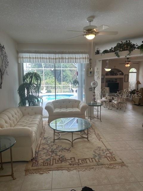 3816 N Cranberry Blvd, North Port, FL 34286 - tiled living area with a ceiling fan, plenty of natural light, and a textured ceiling