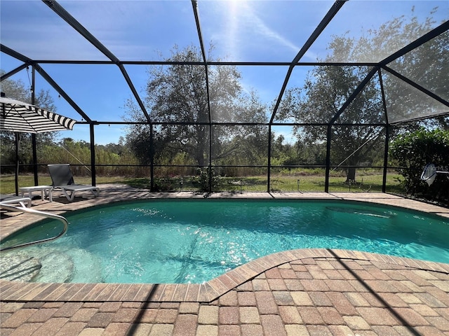 outdoor pool with glass enclosure and a patio area