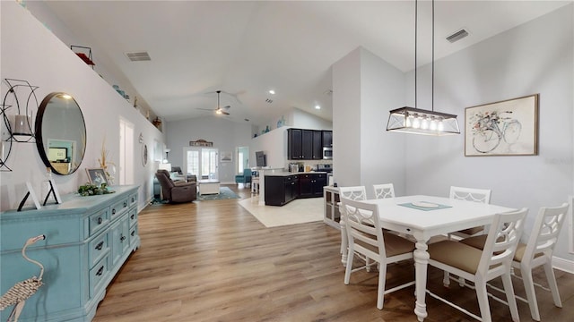 dining space featuring a ceiling fan, lofted ceiling, visible vents, and light wood-style flooring