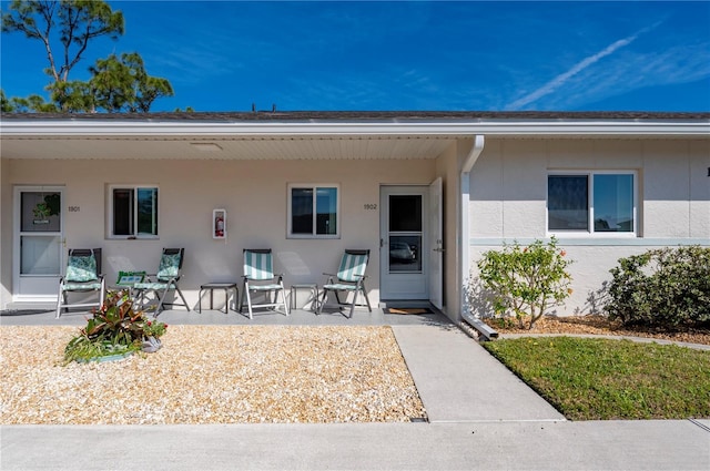 property entrance with a patio area and stucco siding