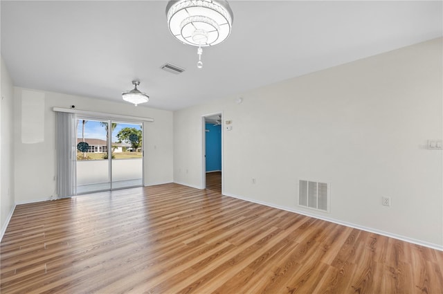 empty room featuring visible vents, light wood-style flooring, and baseboards