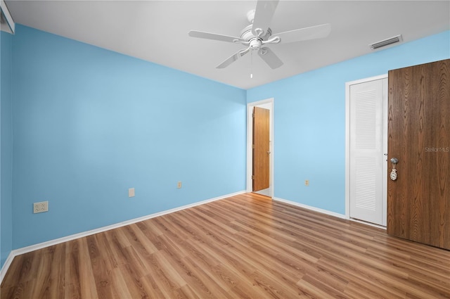 unfurnished bedroom featuring a closet, visible vents, ceiling fan, light wood-type flooring, and baseboards