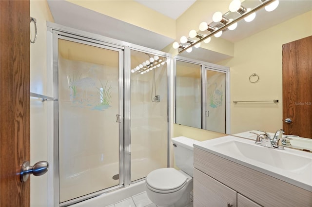 bathroom featuring a stall shower, vanity, toilet, and tile patterned floors