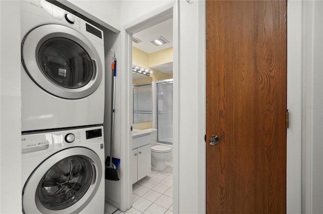 laundry room with stacked washer and dryer, visible vents, light tile patterned floors, and laundry area