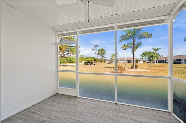 unfurnished sunroom featuring a ceiling fan