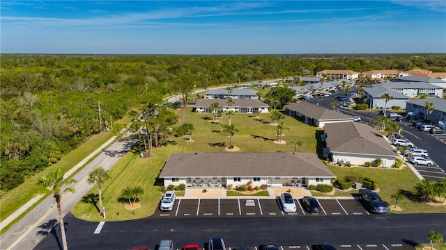 drone / aerial view featuring a wooded view and a residential view