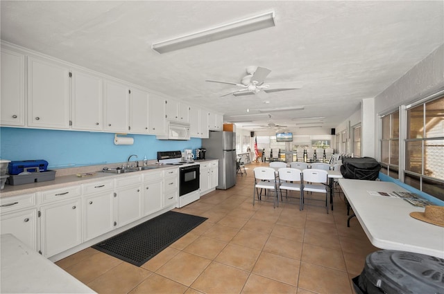 kitchen with light countertops, a ceiling fan, white cabinets, a sink, and white appliances