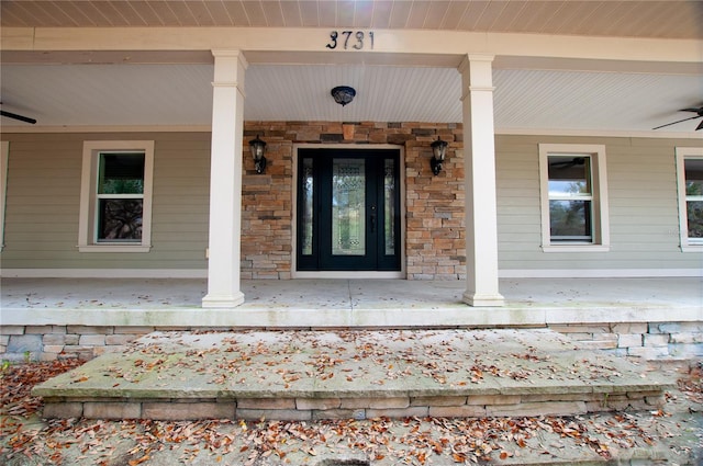 property entrance featuring covered porch, stone siding, and a ceiling fan