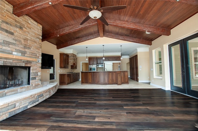 unfurnished living room featuring wood ceiling, a stone fireplace, and lofted ceiling with beams