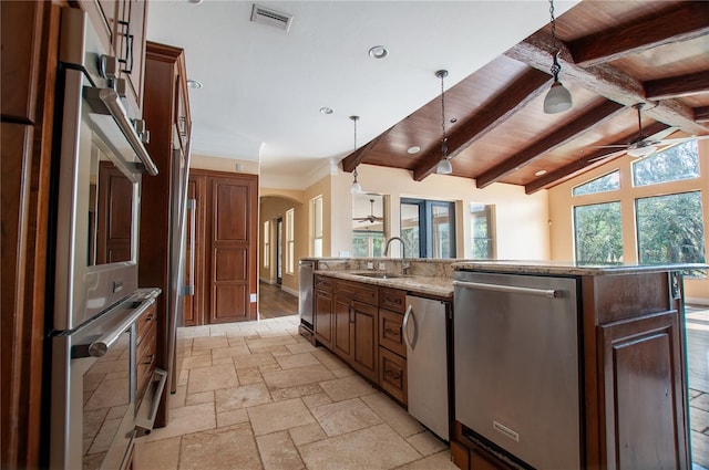 kitchen with a sink, visible vents, appliances with stainless steel finishes, a large island with sink, and pendant lighting