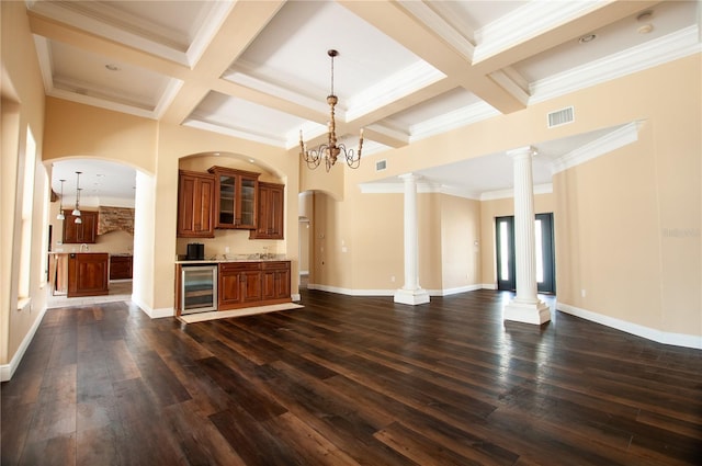 kitchen with beverage cooler, decorative columns, visible vents, glass insert cabinets, and open floor plan