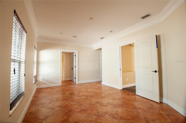 empty room with ornamental molding, visible vents, and baseboards