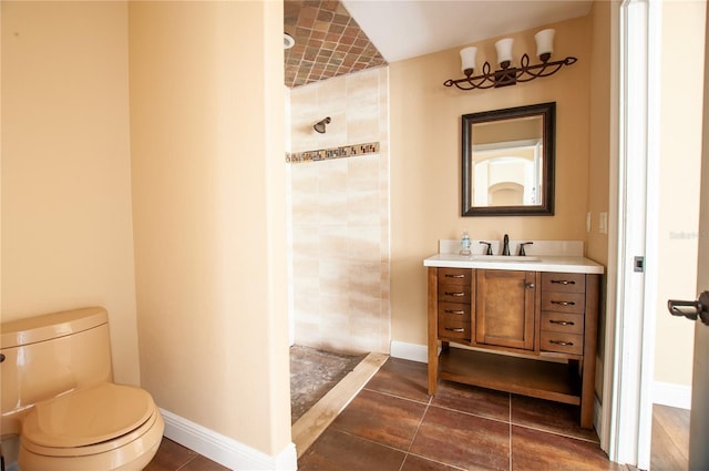 bathroom featuring toilet, baseboards, a walk in shower, and vanity