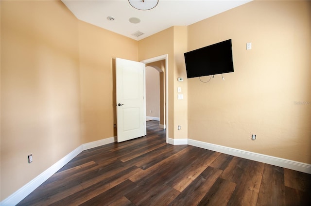 unfurnished bedroom featuring dark wood-type flooring and baseboards