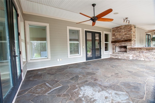 view of patio / terrace with a large fireplace, ceiling fan, and french doors