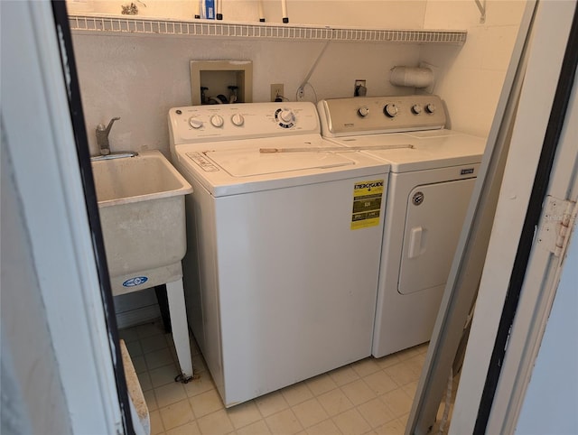 clothes washing area featuring laundry area, independent washer and dryer, and a sink