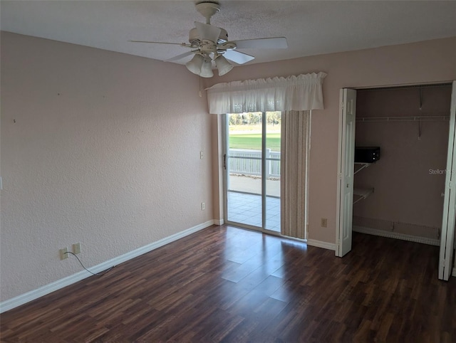 unfurnished bedroom with access to outside, a closet, wood finished floors, and baseboards