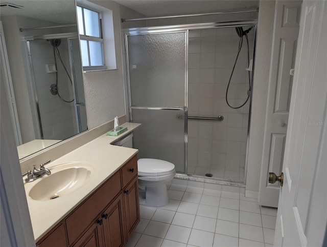 full bathroom featuring a stall shower, vanity, toilet, and tile patterned floors