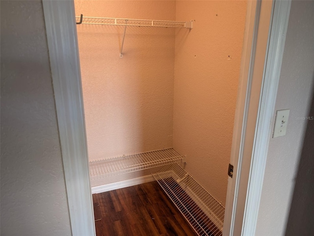 walk in closet with wood finished floors