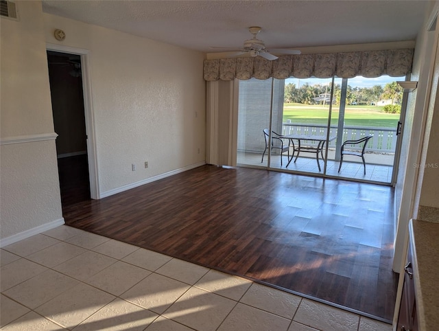 empty room with visible vents, a textured wall, ceiling fan, a textured ceiling, and tile patterned flooring