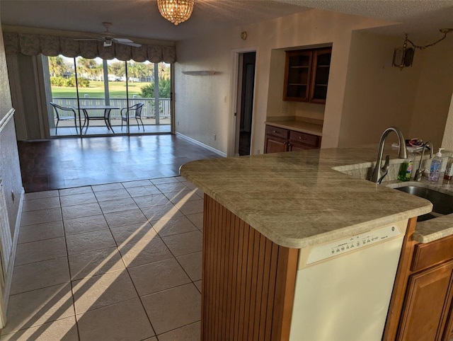 kitchen with light countertops, white dishwasher, a textured ceiling, a sink, and ceiling fan