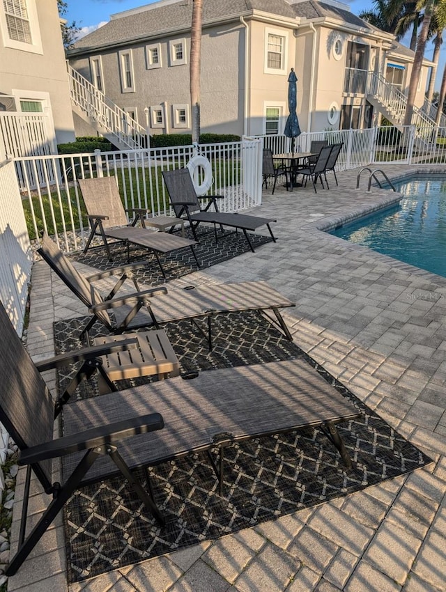 view of patio with fence and a community pool