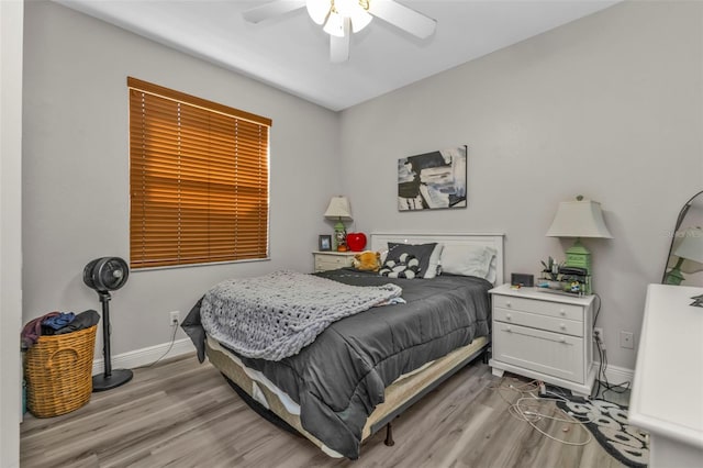 bedroom with light wood-type flooring, ceiling fan, and baseboards