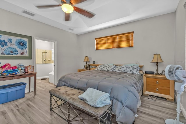 bedroom with baseboards, visible vents, connected bathroom, ceiling fan, and light wood-type flooring