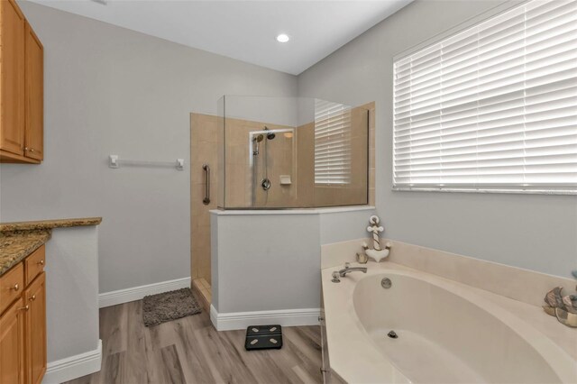 full bathroom featuring baseboards, wood finished floors, walk in shower, vanity, and a bath