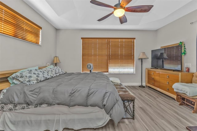 bedroom featuring a ceiling fan, baseboards, and wood finished floors