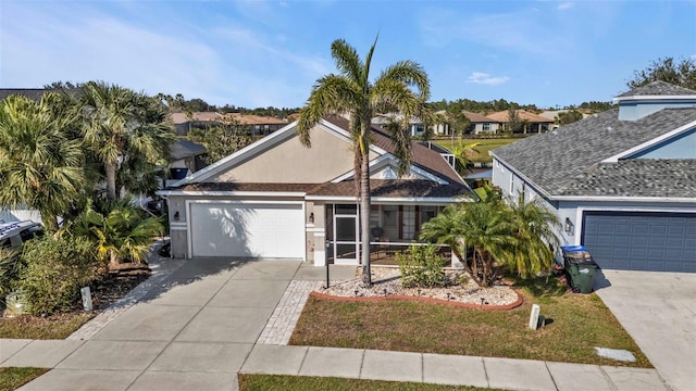 ranch-style home with concrete driveway, an attached garage, and stucco siding