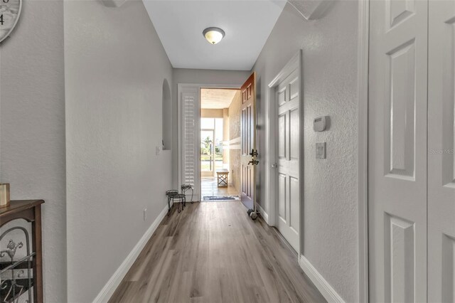 1859 Scarlett Ave, North Port, FL 34289 - corridor with wood finished floors, a textured wall, and arched walkways