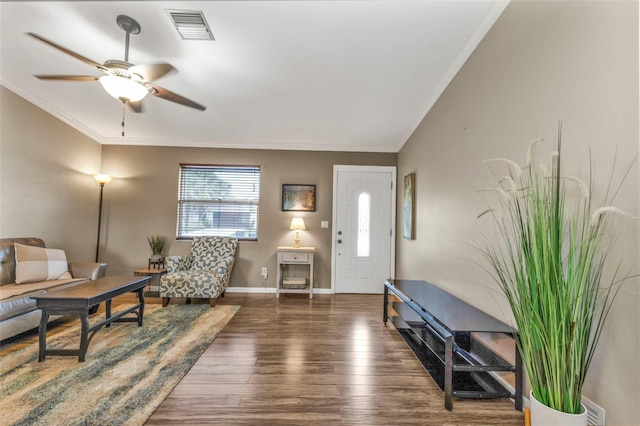 foyer entrance with dark wood-style floors, baseboards, visible vents, and ornamental molding