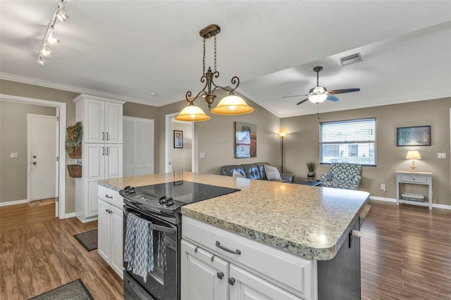 kitchen featuring black range with electric cooktop, visible vents, white cabinets, open floor plan, and a center island