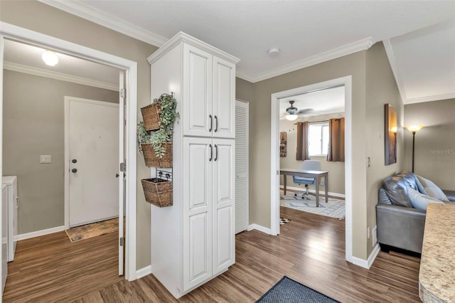 hall featuring baseboards, dark wood-type flooring, and crown molding