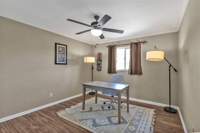 office area featuring ceiling fan, baseboards, dark wood-type flooring, and ornamental molding