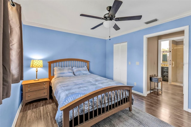 bedroom with dark wood-style flooring, visible vents, baseboards, a closet, and crown molding